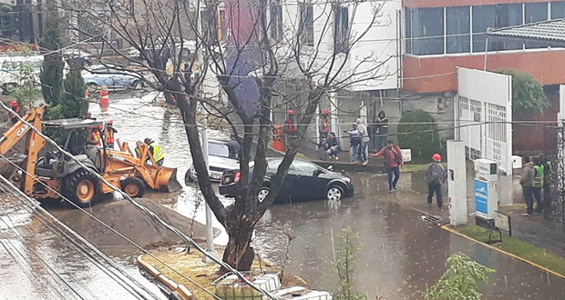 un auto en un hoyo inundado y en la 18 sur y 31 oriente