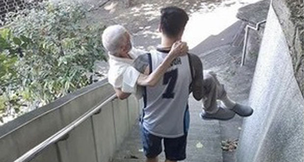 En Taiwán, joven lleva cargando a su abuelito para vacunarse