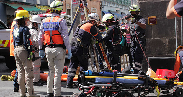 Mujer cae a registro destapado en Puebla; Protección Civil la rescata 