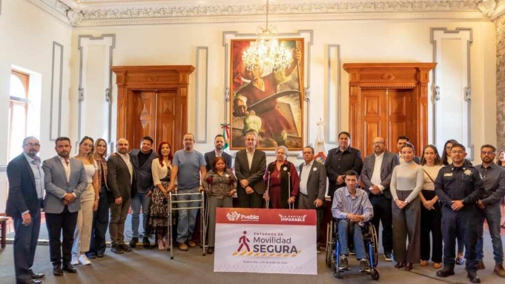 Grupo de personas reunidas en un salón institucional o gubernamental, posando para una foto oficial.